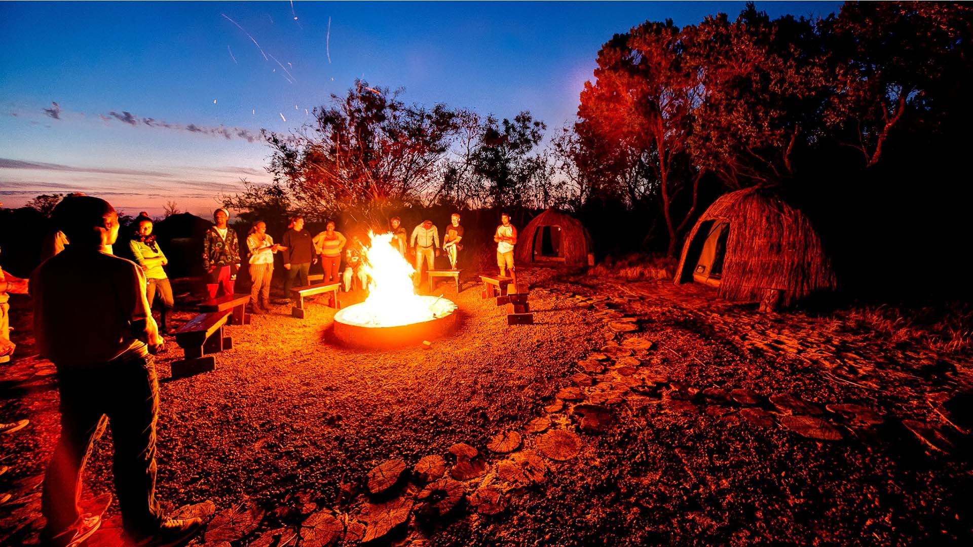 khwattu turisti intorno al fuoco di un villaggio San a kwattu