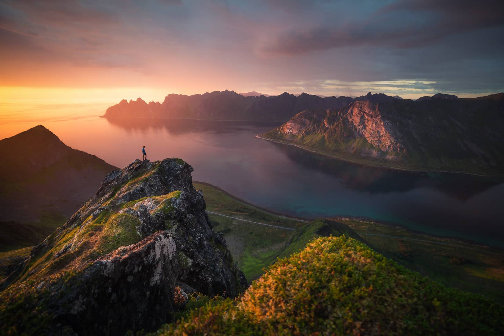 senja_norway Ragazzo osserva il tramonto sopra il fiordo di Senja